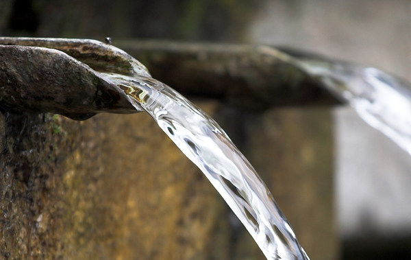 Water running from a tap which is part of a fountain.