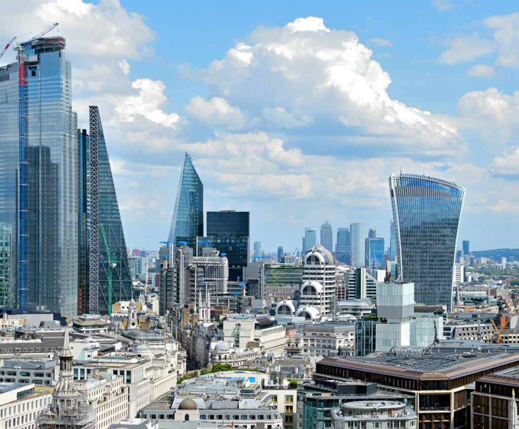 View of the City of London, with the Walkie Talkie building in focus and Canary Wharf in the background.