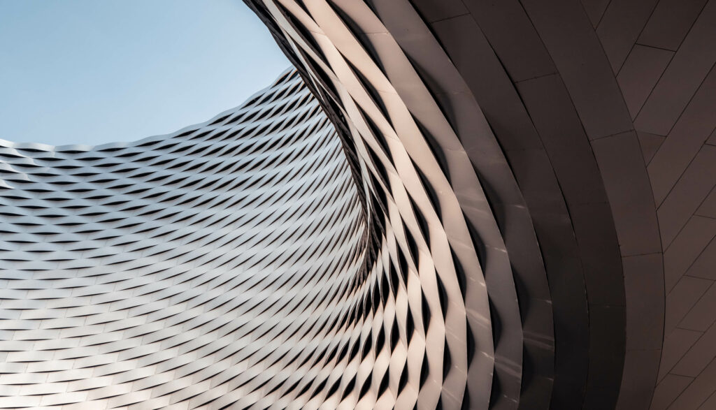 Abstract building with a wavy facade against a blue sky.
