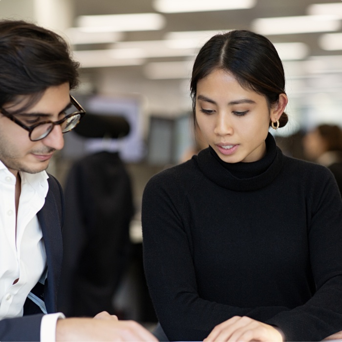 A male and female engaging in conversation in an office.